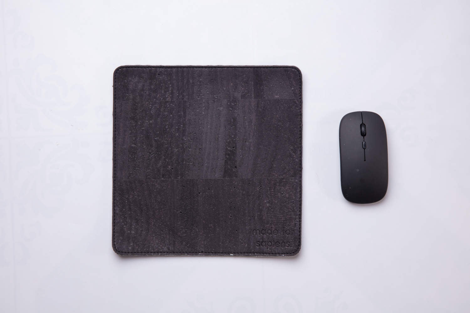 Black travel mousepad with wireless mouse next to it