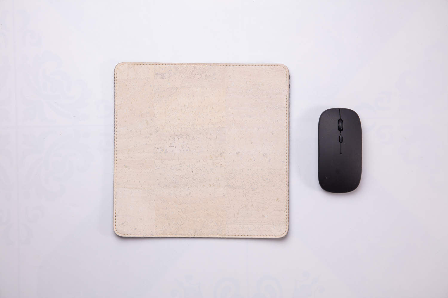 White travel mousepad with wireless mouse next to it