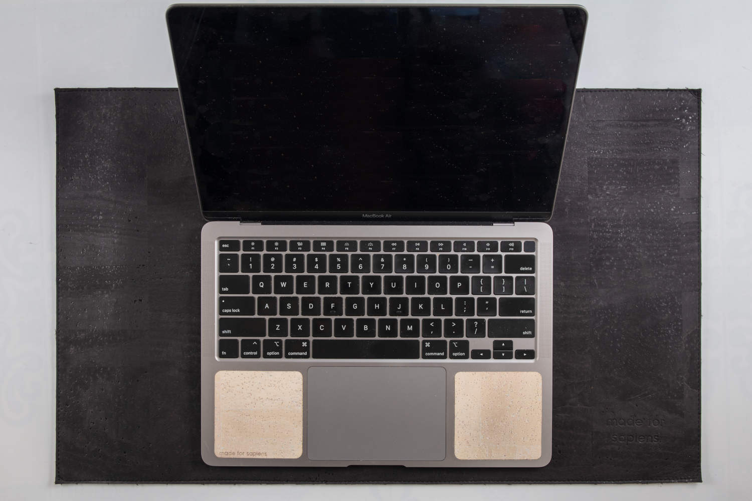 Overhead view of 13-inch Macbook on black cork leather laptop desk pad