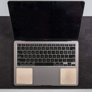 Overhead view of 13-inch Macbook on black cork leather laptop desk pad