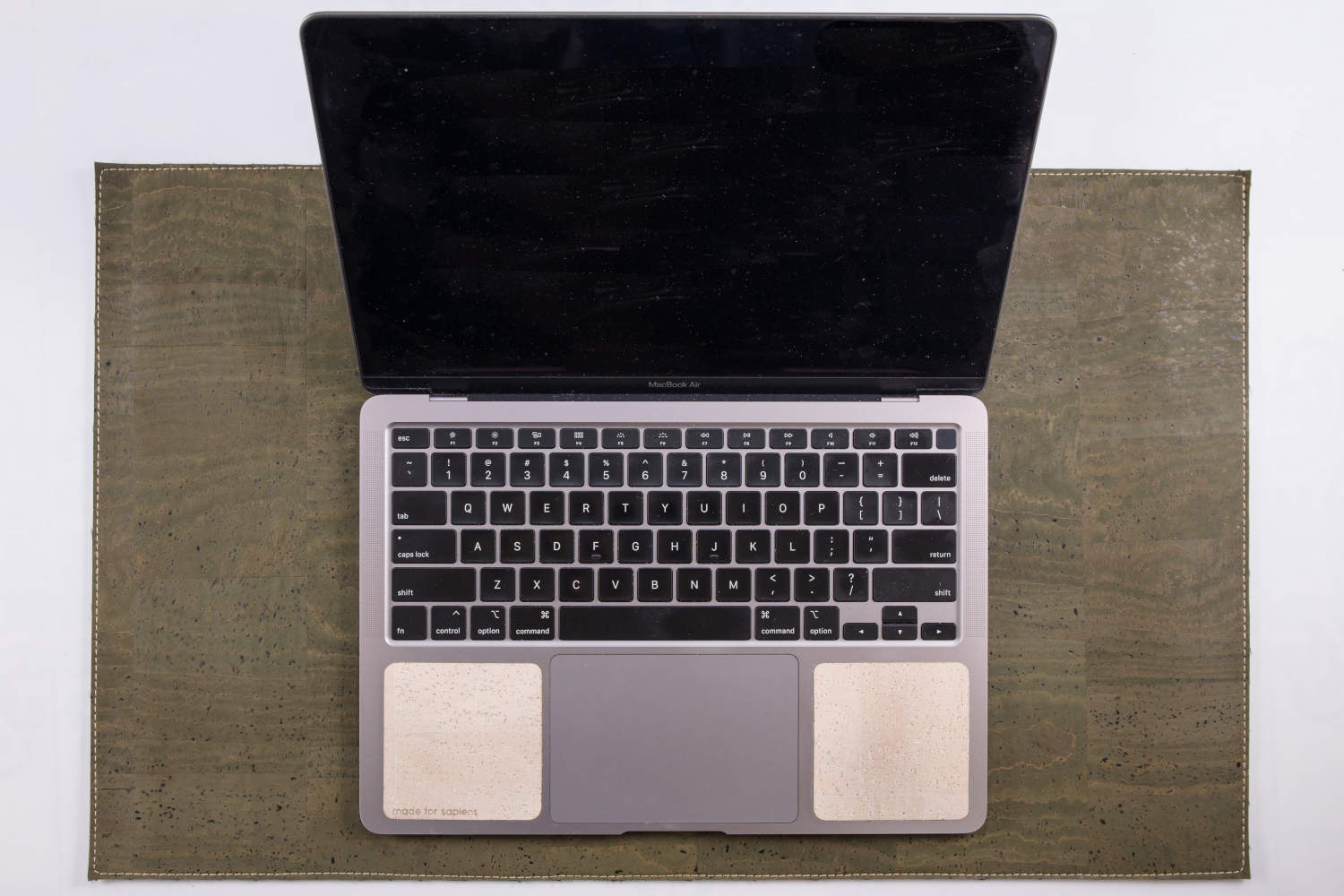 Overhead view of 13-inch Macbook on green cork leather laptop desk pad