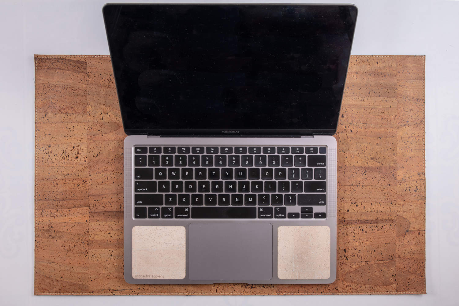 Overhead view of 13-inch Macbook on tan cork leather laptop desk pad