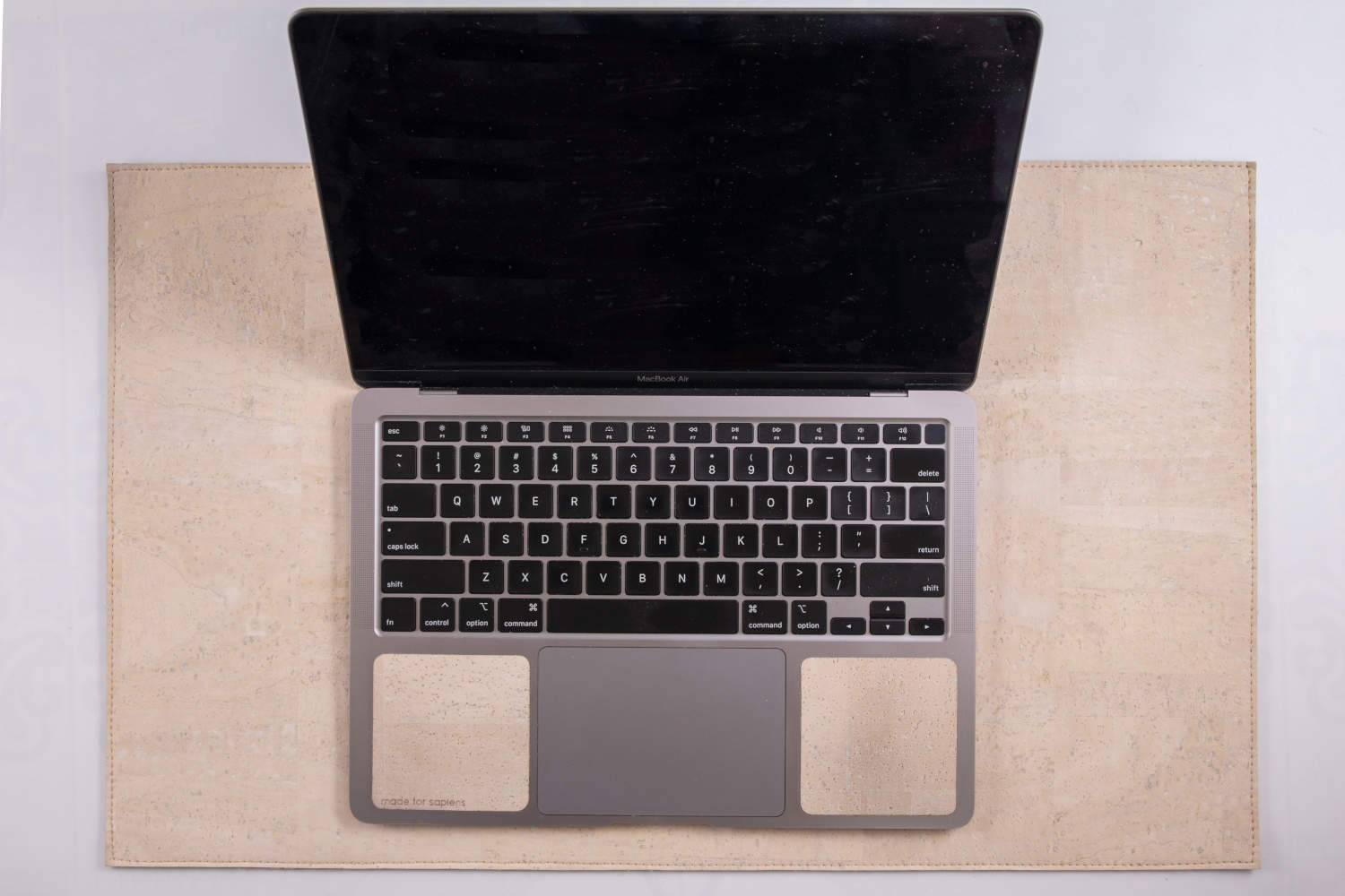 Overhead view of 13-inch Macbook on white cork leather laptop desk pad
